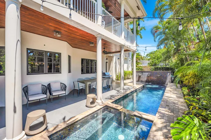 Full glass tile pool and spa with water feature.