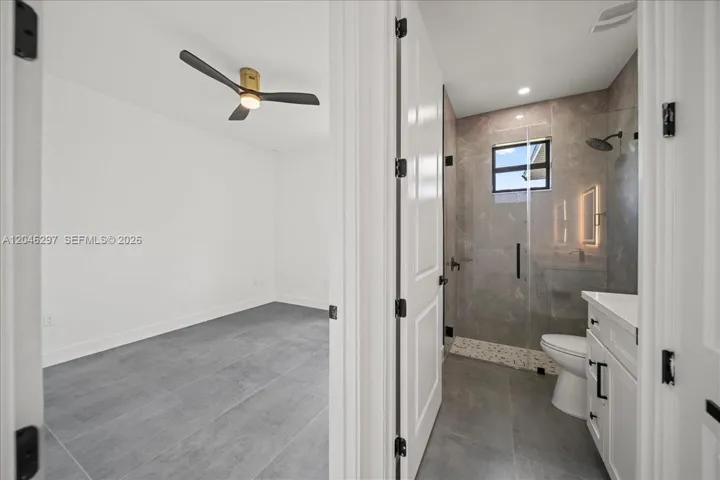 Spa-inspired bathroom featuring a dual-sink quartz vanity, illuminated designer mirrors