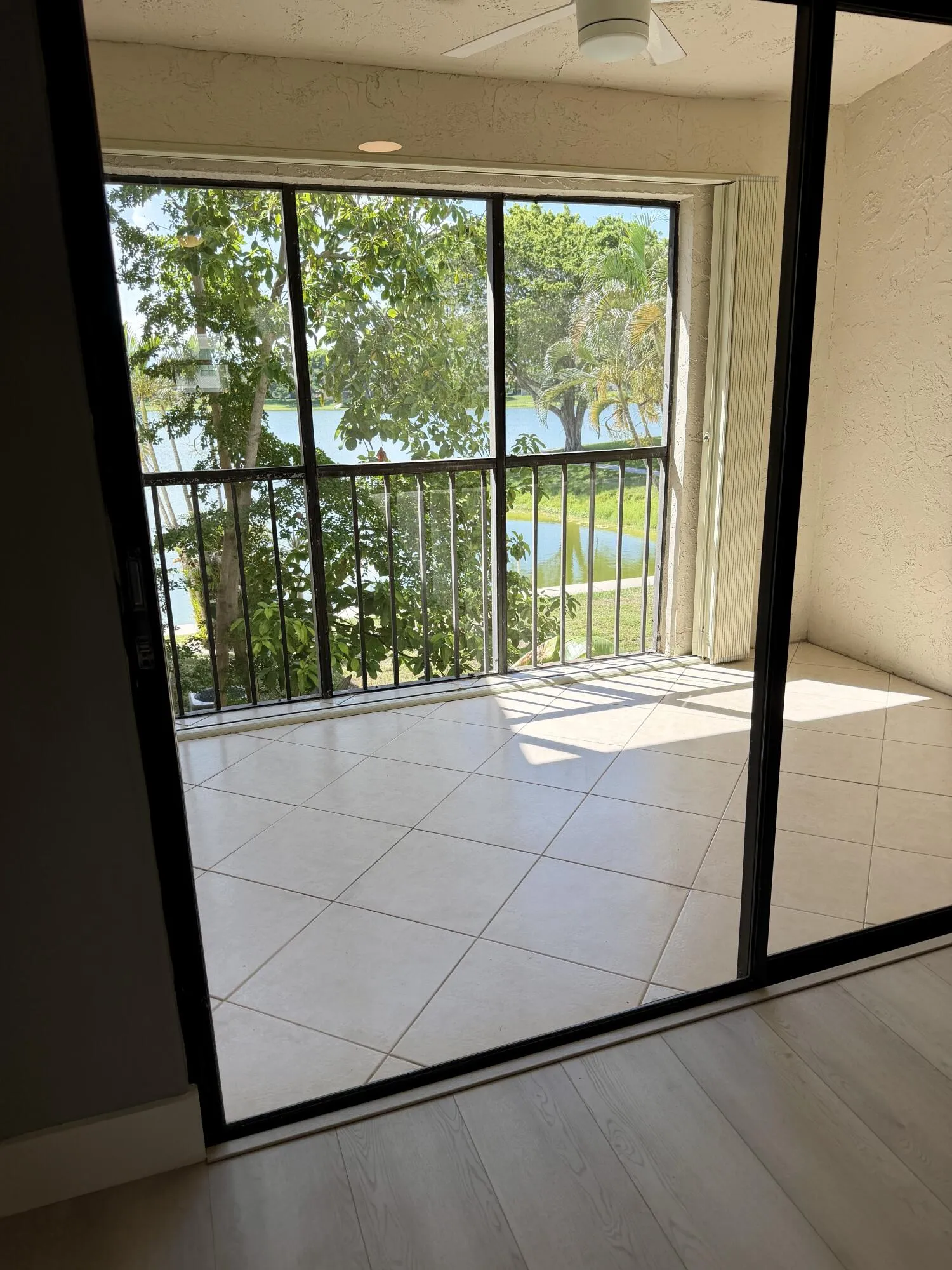 Serene balcony with tile floors, fan, nice lake view & hurricane protection