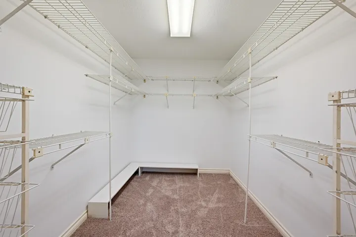 Generously sized primary walk-in closet.