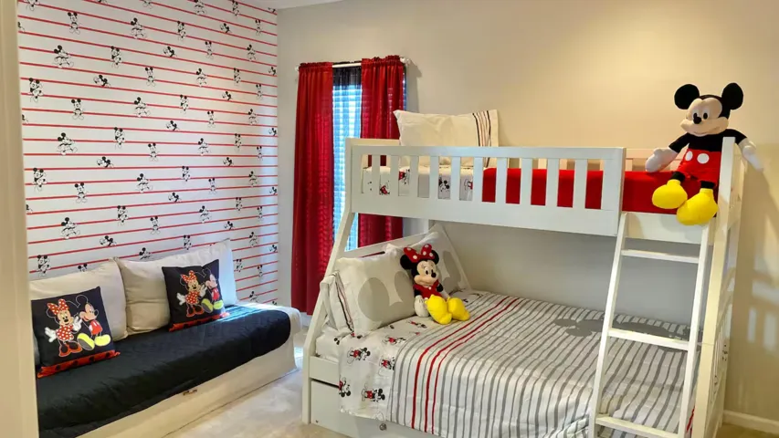 Mickey & Minnie–themed suite featuring playful décor, a cozy sitting area, and an adjoining bathroom—a cheerful retreat to unwind after a day at the parks.
