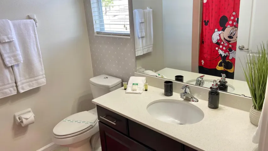 Mickey & Minnie–themed suite featuring playful décor, a cozy sitting area, and an adjoining bathroom—a cheerful retreat to unwind after a day at the parks.