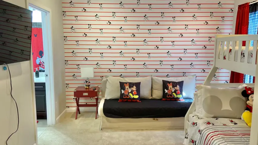Mickey & Minnie–themed suite featuring playful décor, a cozy sitting area, and an adjoining bathroom—a cheerful retreat to unwind after a day at the parks.