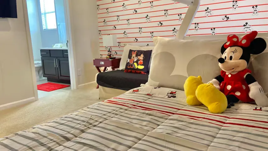Mickey & Minnie–themed suite featuring playful décor, a cozy sitting area, and an adjoining bathroom—a cheerful retreat to unwind after a day at the parks.