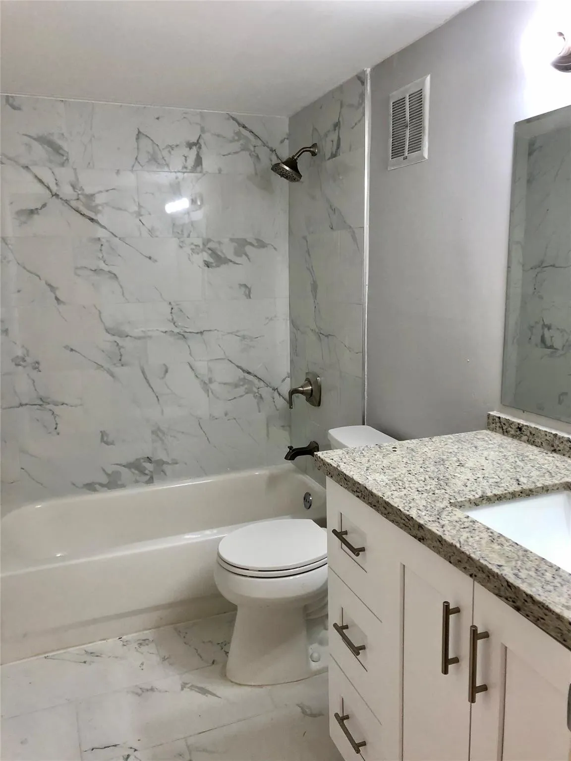 GUEST BATH TOTALLY UPDATED WITH PORCELAIN MARBLE TILE