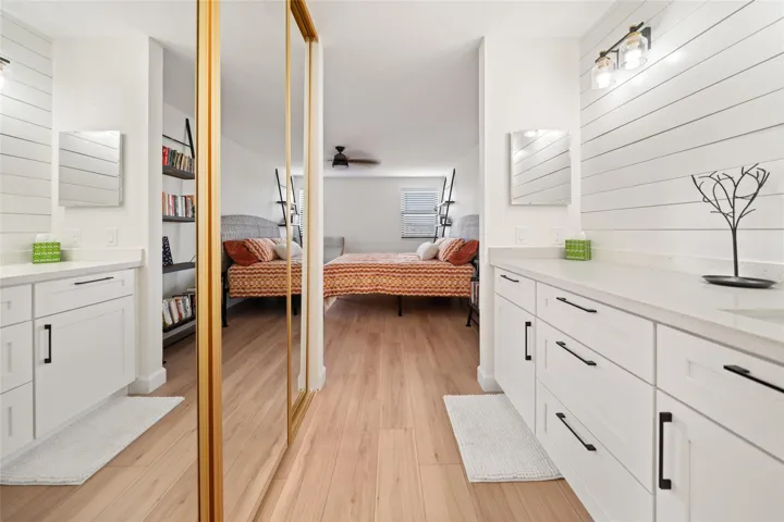 Primary dressing area leading into walk-in closet and bathroom