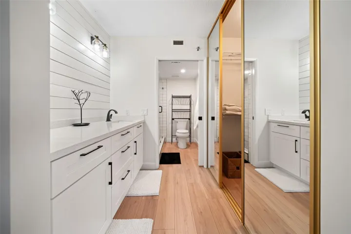 Primary dressing area leading into walk-in closet and bathroom
