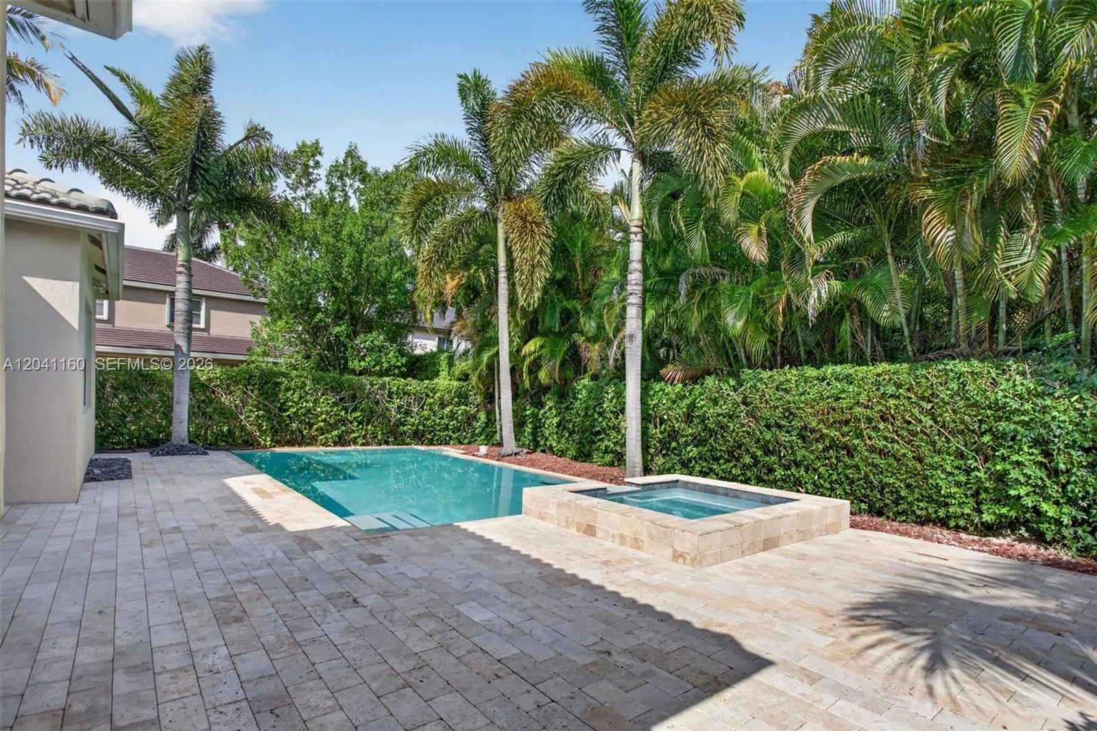 Large patio with marble pavers and a heated jacuzzi.