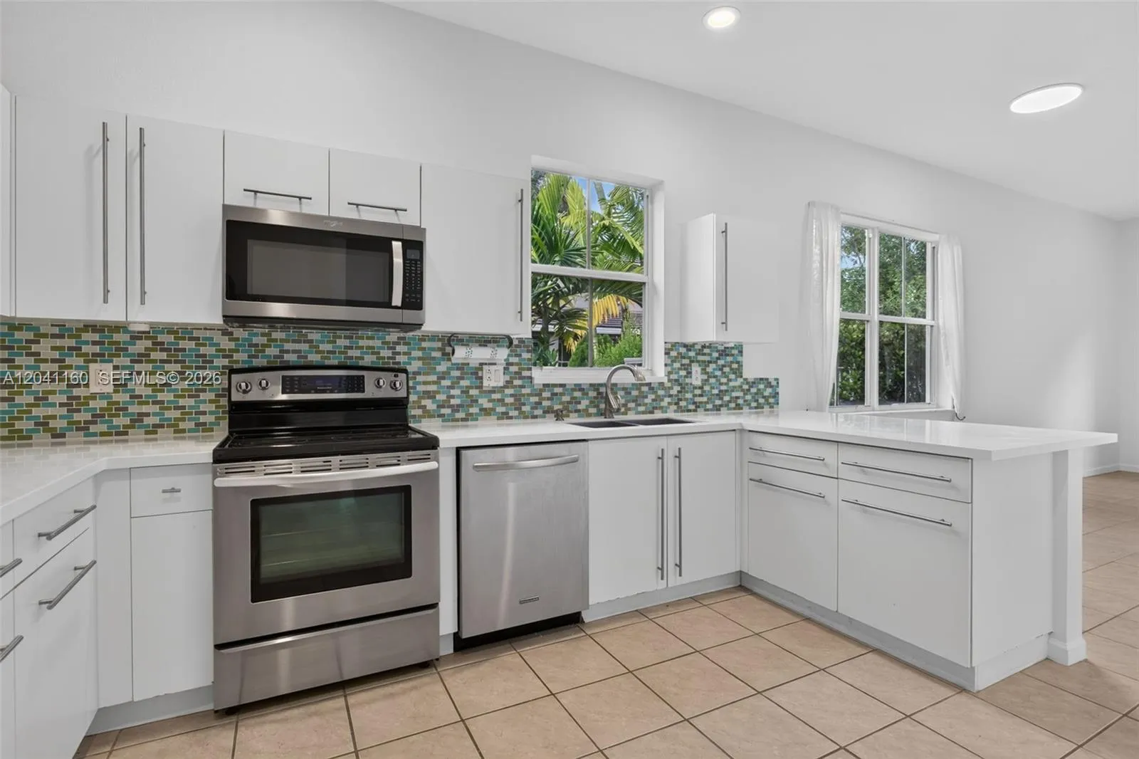 Bright, modern kitchen with tile backsplash and breakfast counter.