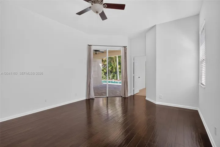 Primary bedroom with sliding glass doors leading to patio and pool.