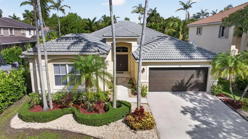 Impressive curb appeal with lush tropical landscaping and majestic palms.