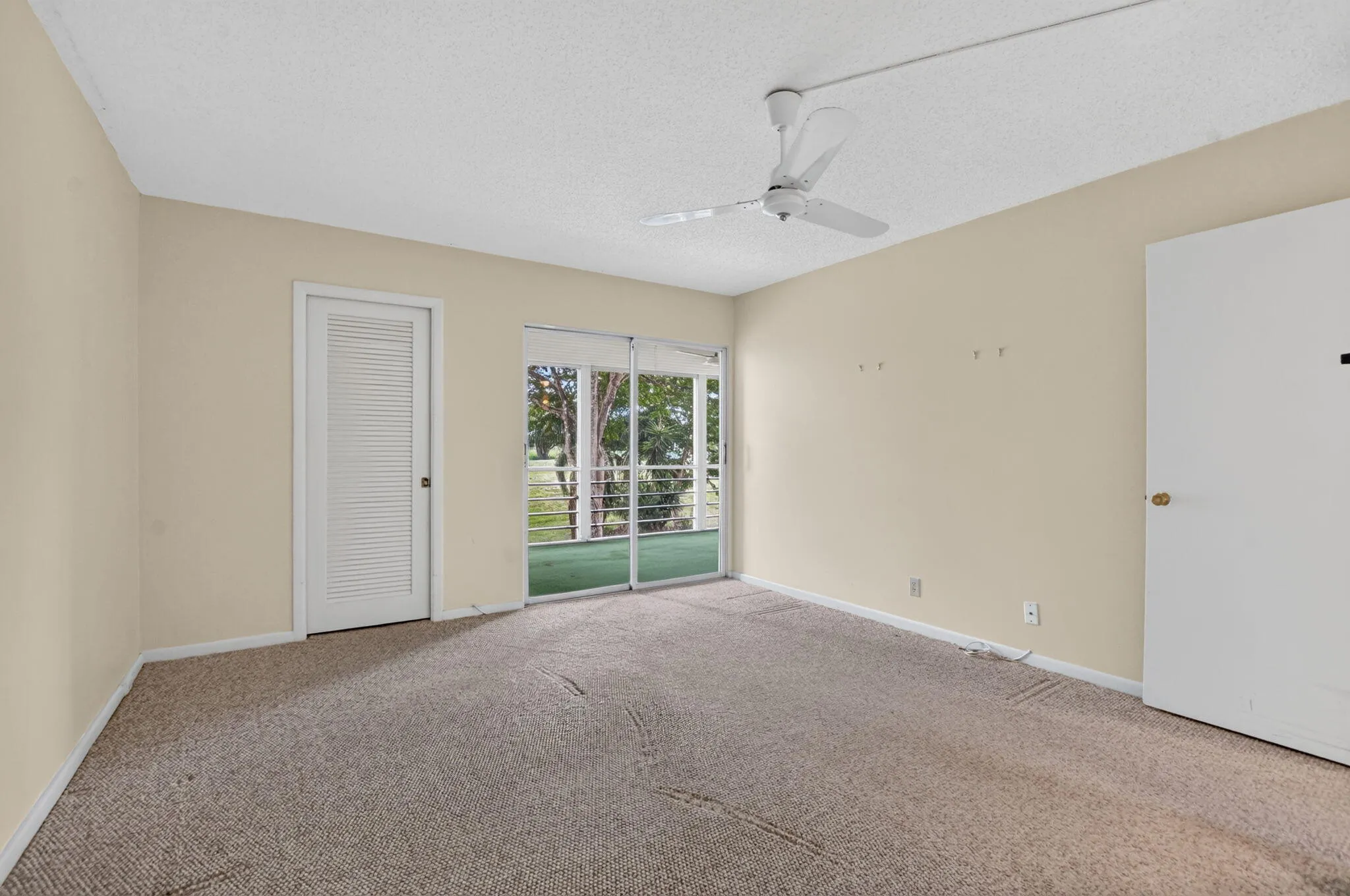 Primary bedroom sliders allow access to the screen patio and view of the gardens!