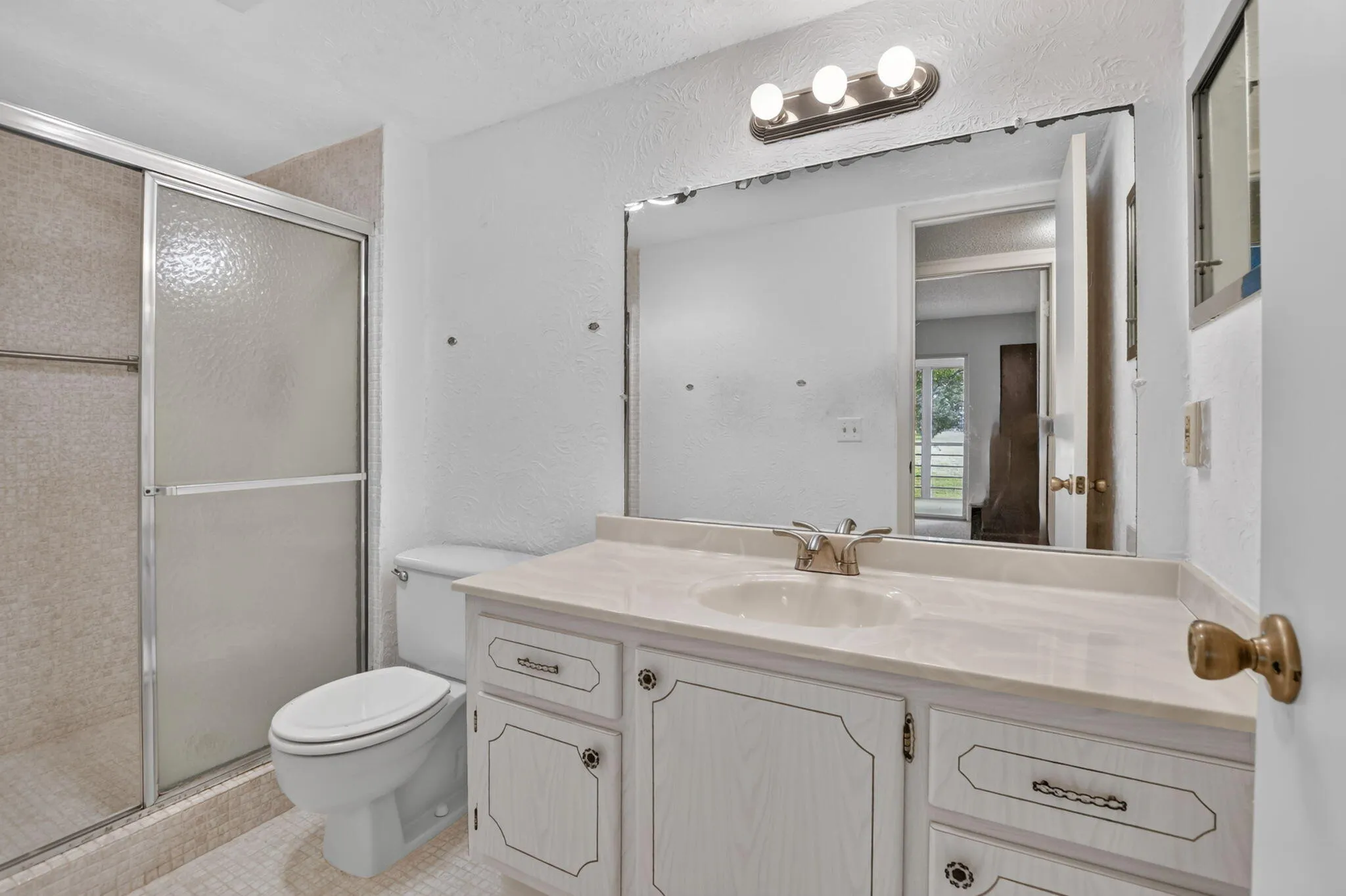 Guest bathroom has custom standing shower option and plenty of cabinetry.