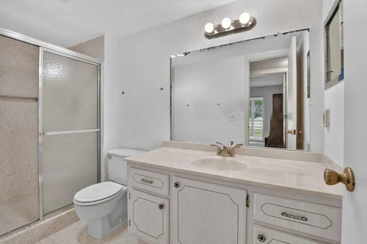 Guest bathroom has custom standing shower option and plenty of cabinetry.