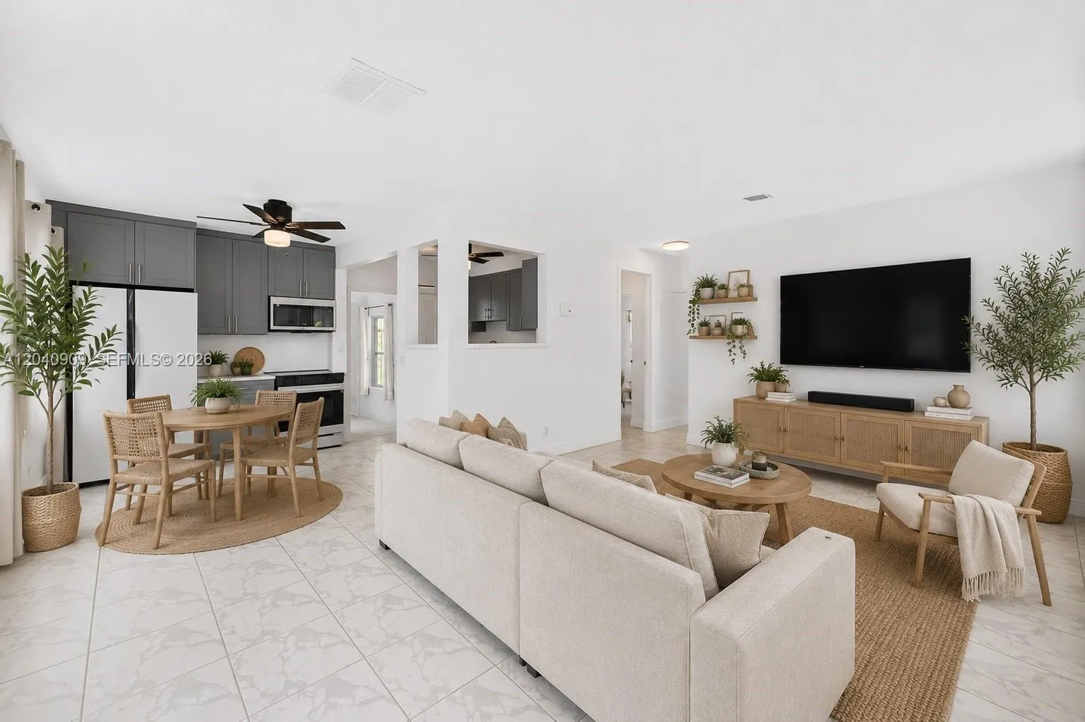 To the right are 2 bedrooms and a bathroom. The front door is not shown but would be by the single chair oon the right. Through the kitchen is a den and primary bedroom to the pool area. Image digitally enhanced. AI used for staging purposes