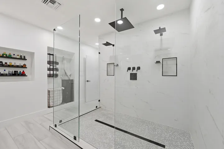 Spa inspired shower featuring multiple shower heads, including a luxurious rain shower for a truly relaxing experience.