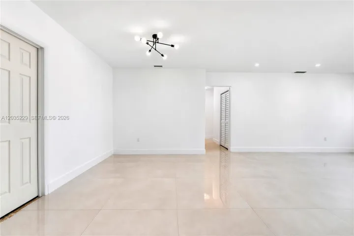 Open-concept living and dining area with modern lighting.