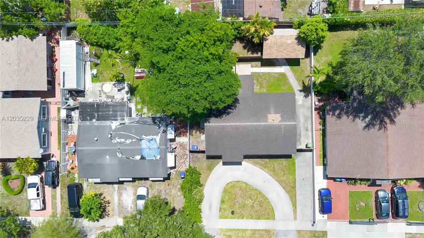 Aerial view showcasing the circular driveway, spacious lot, and mature trees.