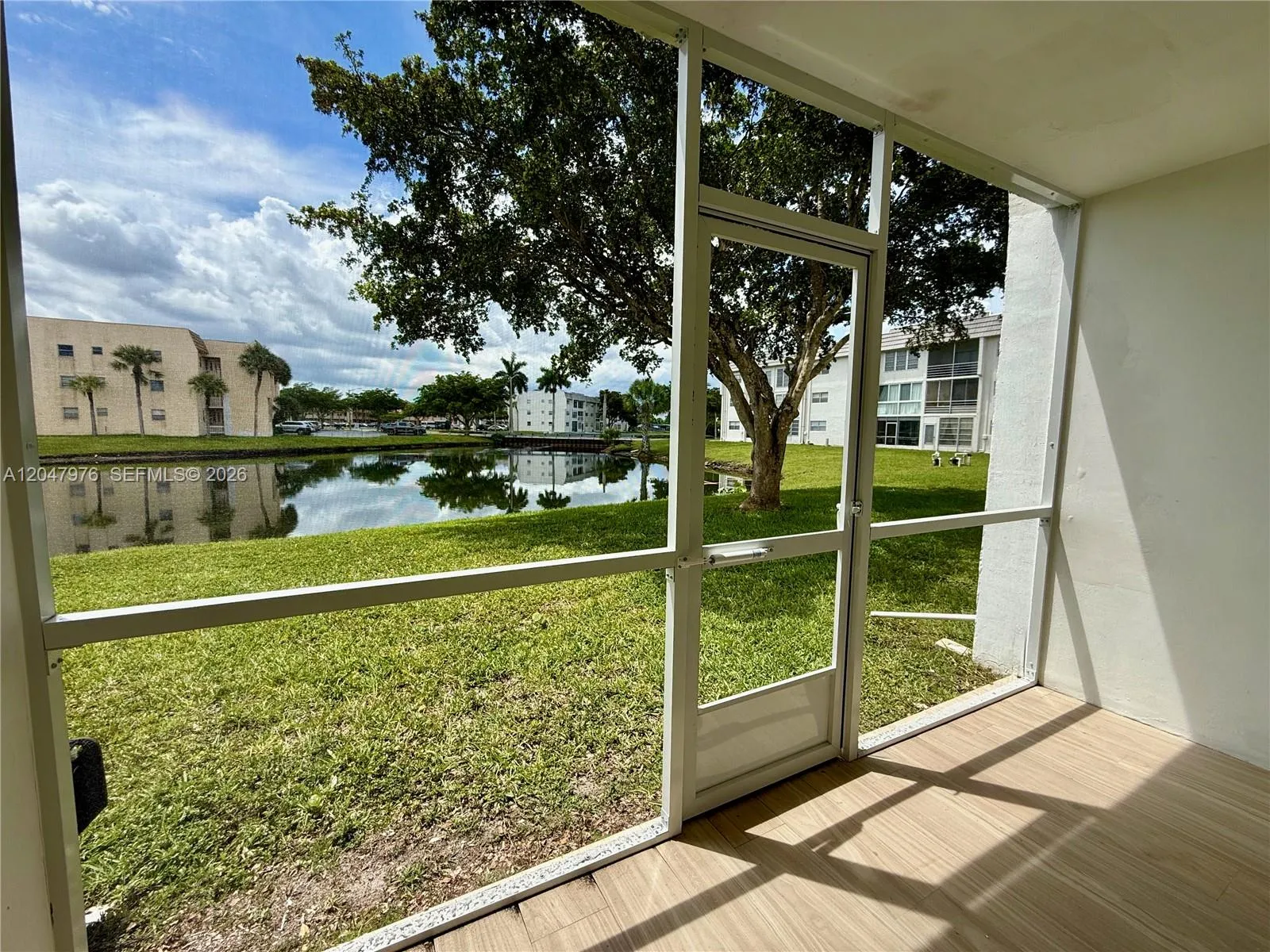 Tiled, screened in balcony with peaceful lake view.
