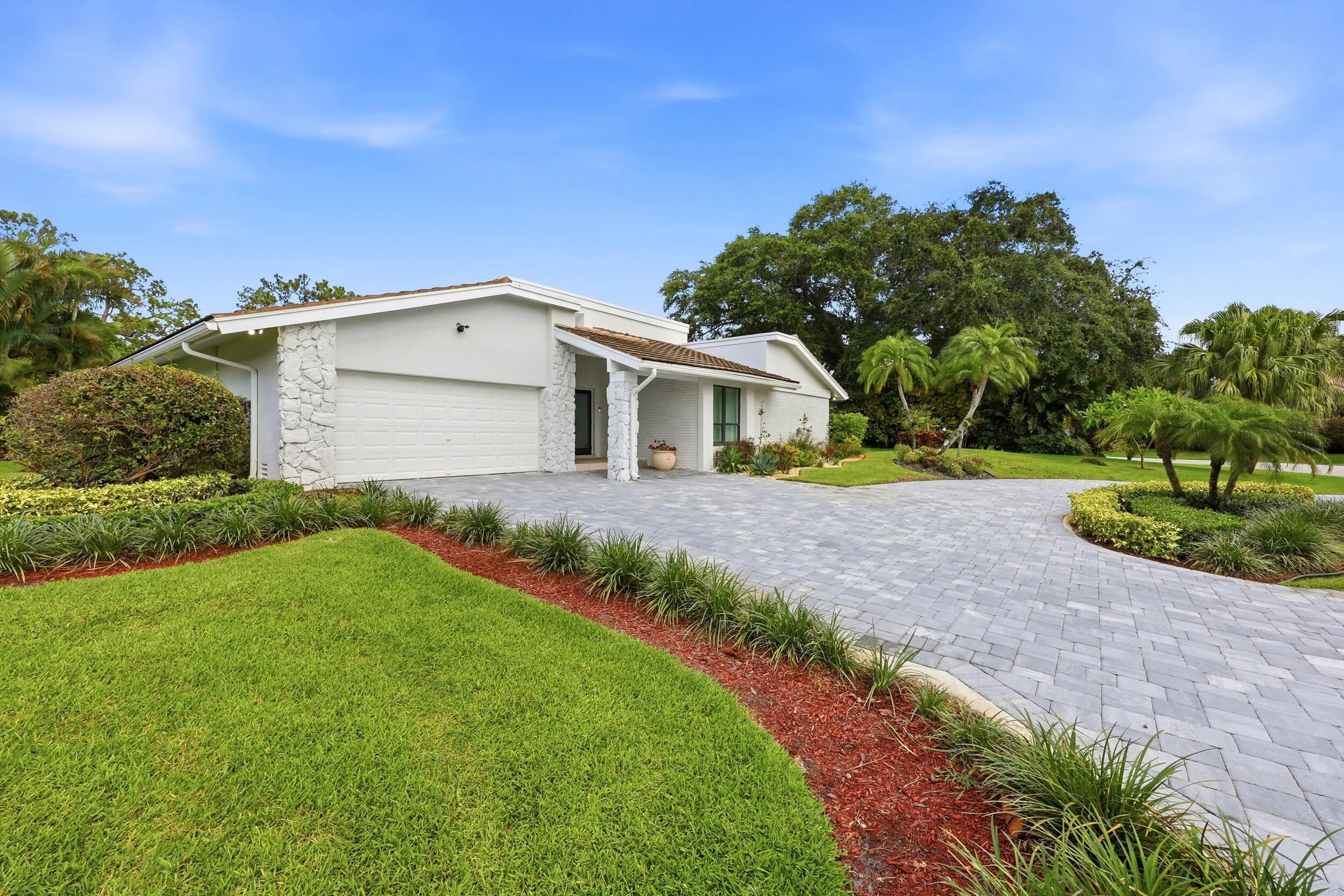 A striking first impression begins with a sweeping paver driveway, lush tropical landscaping, and timeless architectural details that set this home apart. Sitting on a beautifully maintained oversized-corner lot within the gated highly sought after community of Seagate Country Club, this home offers exceptional curb appeal, mature greenery, and a sense of privacy that is increasingly difficult to find in central Delray Beach.