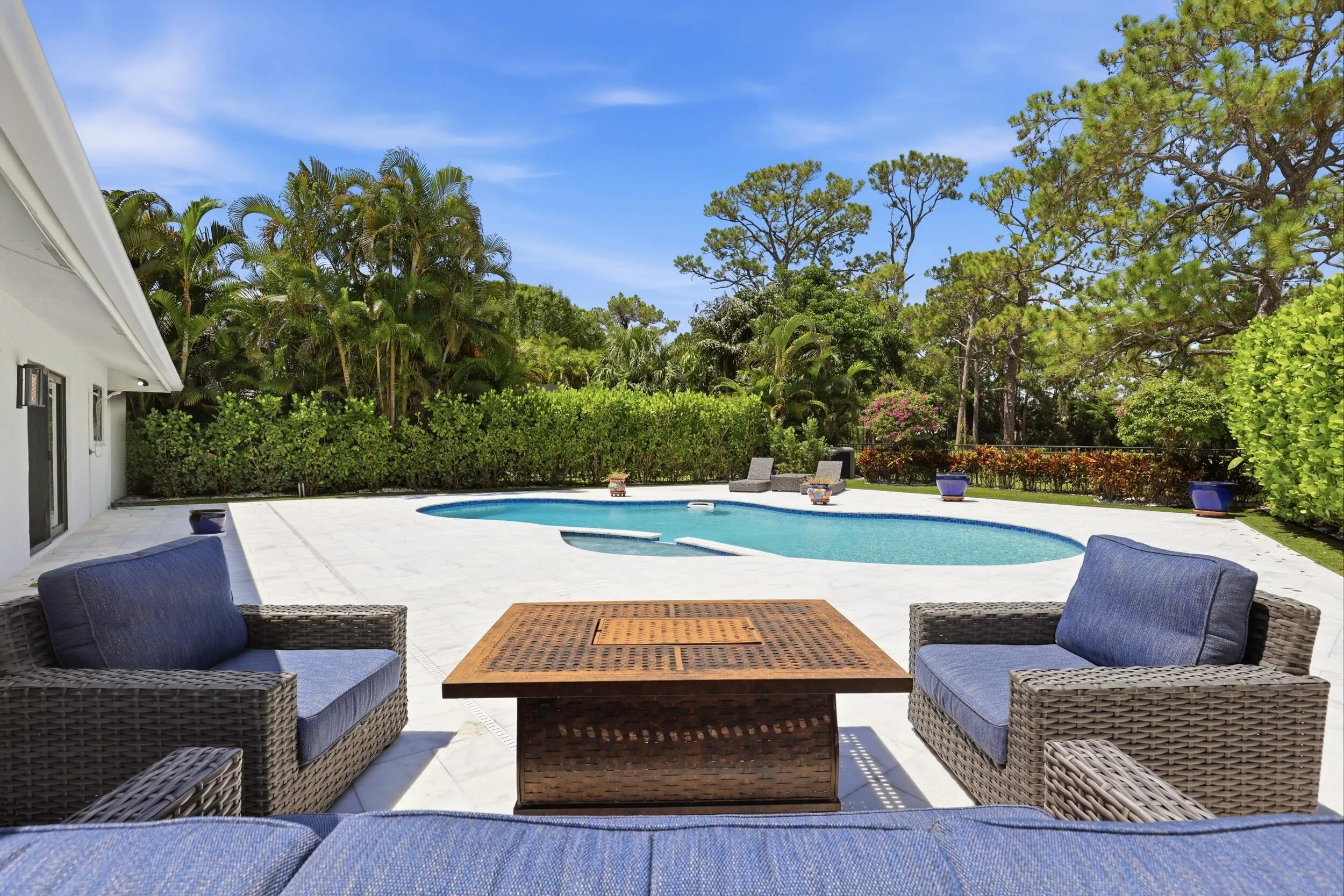 Discover your own private backyard sanctuary where modern luxury meets the natural beauty of Old Florida. Backing directly to a nature preserve, this extraordinary outdoor retreat offers a level of privacy rarely found in South Florida, creating a peaceful setting with no rear neighbors and lush tropical views in every direction. A newly renovated freeform pool and spa are surrounded by an expansive marble pool deck, offering the perfect backdrop for relaxing afternoons or effortless entertaining.
Thoughtfully designed as an extension of the home, the backyard features multiple spaces to lounge, dine, and gather, all immersed in the serenity of the surrounding preserve. Whether enjoying your morning coffee, an evening swim, or hosting friends and family, every moment is enhanced by the tranquil landscape and exceptional sense of seclusion that defines this remarkable property.