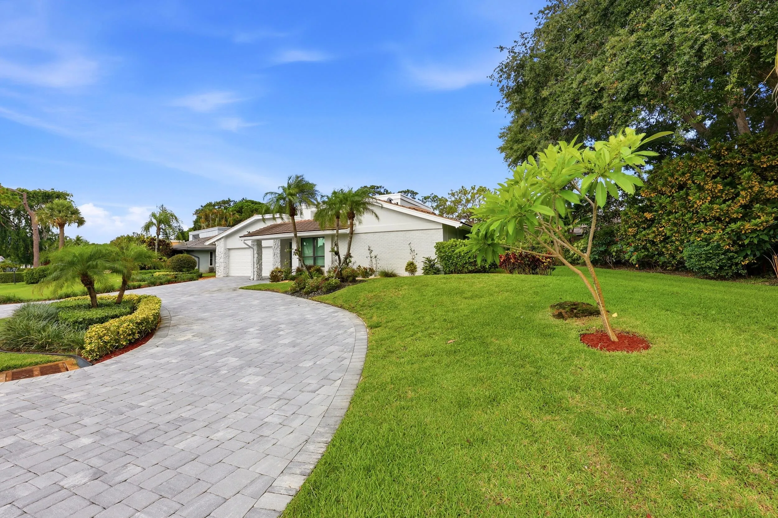 A striking first impression begins with a sweeping paver driveway, lush tropical landscaping, and timeless architectural details that set this home apart. Sitting on a beautifully maintained oversized-corner lot within the gated highly sought after community of Seagate Country Club, this home offers exceptional curb appeal, mature greenery, and a sense of privacy that is increasingly difficult to find in central Delray Beach.
