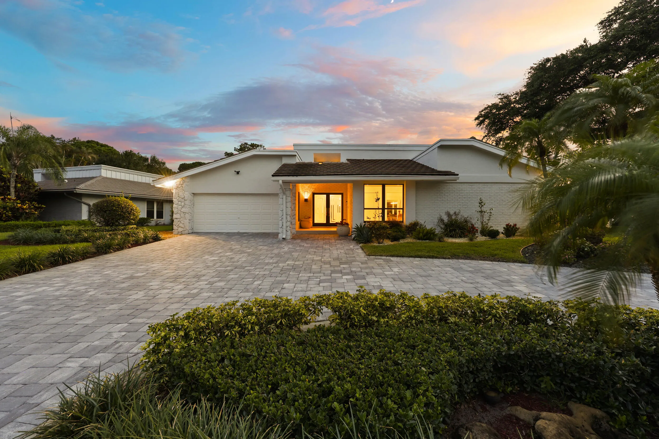 A striking first impression begins with a sweeping paver driveway, lush tropical landscaping, and timeless architectural details that set this home apart. Sitting on a beautifully maintained oversized-corner lot within the gated highly sought after community of Seagate Country Club, this home offers exceptional curb appeal, mature greenery, and a sense of privacy that is increasingly difficult to find in central Delray Beach.