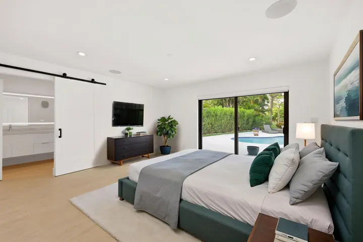Designed as a true private guest retreat, this spacious suite offers exceptional comfort, privacy, and direct access to the backyard through oversized hurricane impact sliding glass doors. A massive custom closet and beautifully renovated ensuite bathroom provide the feel of a luxury hotel suite, while just outside your door, the pool, outdoor shower, and peaceful preserve setting create a secluded oasis for family and guests alike. Thoughtfully positioned away from the main living areas, this inviting space delivers both independence and tranquility.
