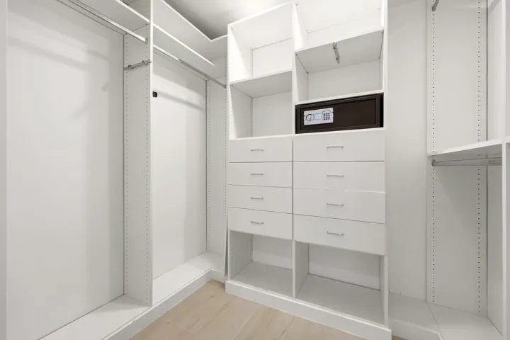 Designed for organization and convenience, this custom walk-in closet offers an impressive amount of storage with built-in shelving, abundant hanging space, multiple drawers, and dedicated accessory storage. Thoughtfully designed to maximize functionality, it provides a boutique-style dressing experience for all of your guests, while keeping everything neatly organized and easily accessible.