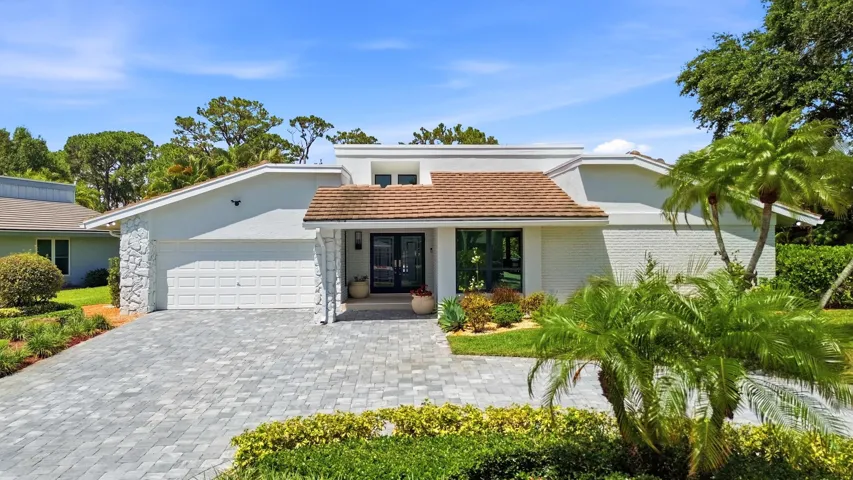 A striking first impression begins with a sweeping paver driveway, lush tropical landscaping, and timeless architectural details that set this home apart. Sitting on a beautifully maintained oversized-corner lot within the gated highly sought after community of Seagate Country Club, this home offers exceptional curb appeal, mature greenery, and a sense of privacy that is increasingly difficult to find in central Delray Beach.