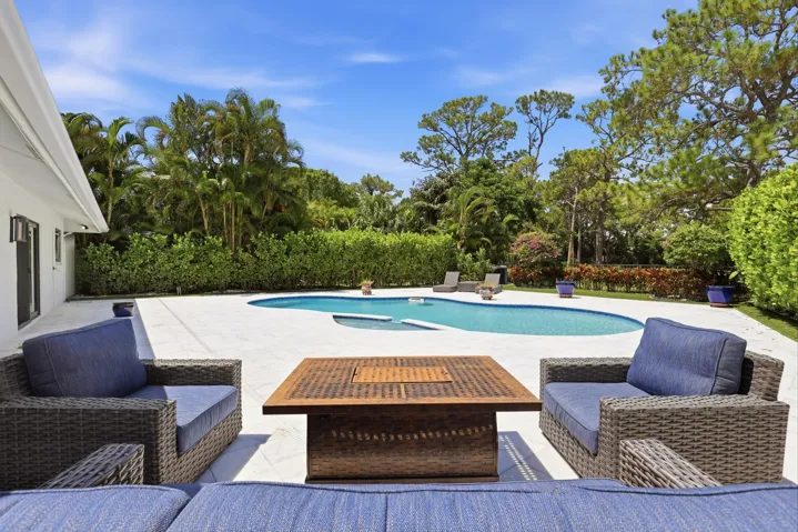 Discover your own private backyard sanctuary where modern luxury meets the natural beauty of Old Florida. Backing directly to a nature preserve, this extraordinary outdoor retreat offers a level of privacy rarely found in South Florida, creating a peaceful setting with no rear neighbors and lush tropical views in every direction. A newly renovated freeform pool and spa are surrounded by an expansive marble pool deck, offering the perfect backdrop for relaxing afternoons or effortless entertaining.Thoughtfully designed as an extension of the home, the backyard features multiple spaces to lounge, dine, and gather, all immersed in the serenity of the surrounding preserve. Whether enjoying your morning coffee, an evening swim, or hosting friends and family, every moment is enhanced by the tranquil landscape and exceptional sense of seclusion that defines this remarkable property.