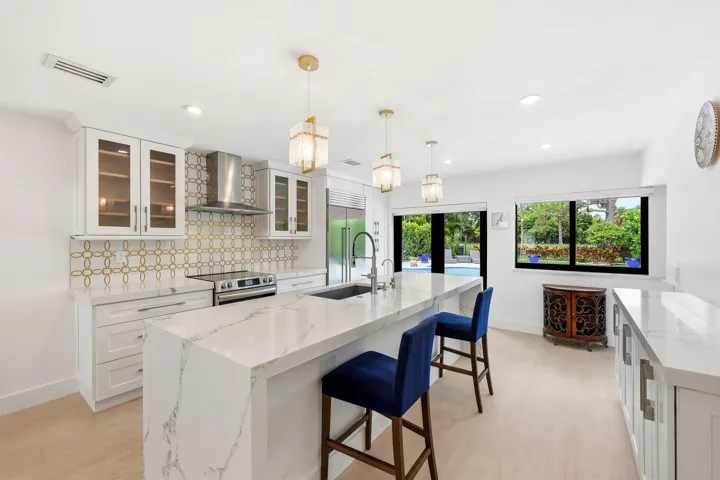 The heart of the home is an impressive open-concept living space defined by soaring vaulted ceilings, exposed beams, skylights, and an abundance of natural light. Designed for both everyday living and entertaining, the expansive great room flows seamlessly into the chef's kitchen and dining areas, while custom built-in cabinetry, wide-plank flooring, and walls of glass create a sophisticated yet inviting atmosphere throughout.