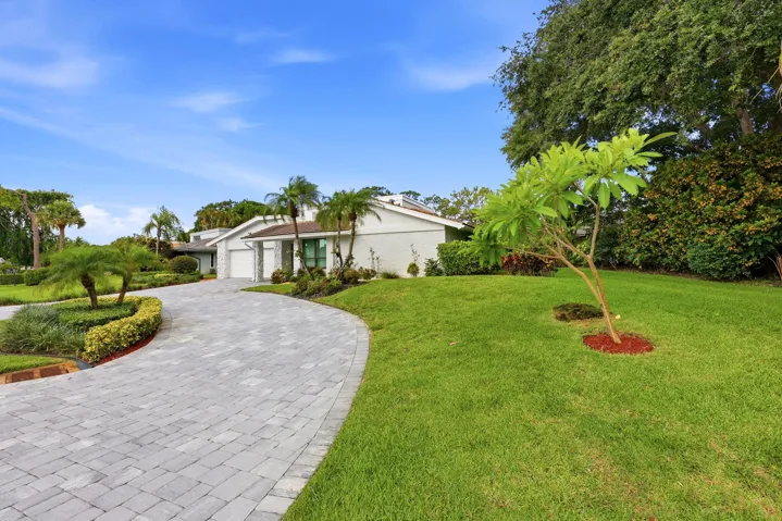 A striking first impression begins with a sweeping paver driveway, lush tropical landscaping, and timeless architectural details that set this home apart. Sitting on a beautifully maintained oversized-corner lot within the gated highly sought after community of Seagate Country Club, this home offers exceptional curb appeal, mature greenery, and a sense of privacy that is increasingly difficult to find in central Delray Beach.