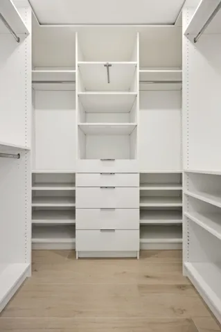 The custom walk-in closet is thoughtfully designed with extensive built-in storage, adjustable shelving, multiple hanging areas, and dedicated drawer space to keep everything organized and easily accessible. Bright, spacious, and highly functional, it provides the perfect complement to the luxurious primary suite.