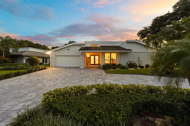A striking first impression begins with a sweeping paver driveway, lush tropical landscaping, and timeless architectural details that set this home apart. Sitting on a beautifully maintained oversized-corner lot within the gated highly sought after community of Seagate Country Club, this home offers exceptional curb appeal, mature greenery, and a sense of privacy that is increasingly difficult to find in central Delray Beach.
