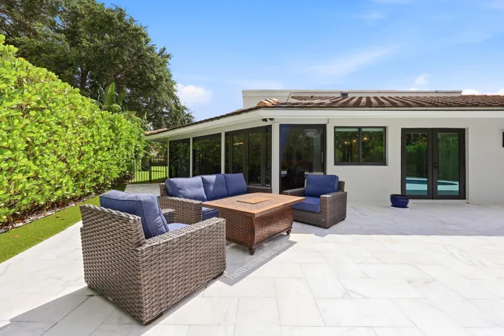 Discover your own private backyard sanctuary where modern luxury meets the natural beauty of Old Florida. Backing directly to a nature preserve, this extraordinary outdoor retreat offers a level of privacy rarely found in South Florida, creating a peaceful setting with no rear neighbors and lush tropical views in every direction. A newly renovated freeform pool and spa are surrounded by an expansive marble pool deck, offering the perfect backdrop for relaxing afternoons or effortless entertaining.Thoughtfully designed as an extension of the home, the backyard features multiple spaces to lounge, dine, and gather, all immersed in the serenity of the surrounding preserve. Whether enjoying your morning coffee, an evening swim, or hosting friends and family, every moment is enhanced by the tranquil landscape and exceptional sense of seclusion that defines this remarkable property.