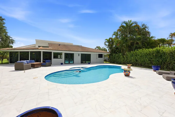 Discover your own private backyard sanctuary where modern luxury meets the natural beauty of Old Florida. Backing directly to a nature preserve, this extraordinary outdoor retreat offers a level of privacy rarely found in South Florida, creating a peaceful setting with no rear neighbors and lush tropical views in every direction. A newly renovated freeform pool and spa are surrounded by an expansive marble pool deck, offering the perfect backdrop for relaxing afternoons or effortless entertaining.Thoughtfully designed as an extension of the home, the backyard features multiple spaces to lounge, dine, and gather, all immersed in the serenity of the surrounding preserve. Whether enjoying your morning coffee, an evening swim, or hosting friends and family, every moment is enhanced by the tranquil landscape and exceptional sense of seclusion that defines this remarkable property.