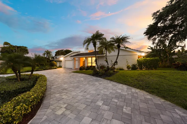 A striking first impression begins with a sweeping paver driveway, lush tropical landscaping, and timeless architectural details that set this home apart. Sitting on a beautifully maintained oversized-corner lot within the gated highly sought after community of Seagate Country Club, this home offers exceptional curb appeal, mature greenery, and a sense of privacy that is increasingly difficult to find in central Delray Beach.
