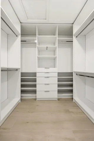 The custom walk-in closet is thoughtfully designed with extensive built-in storage, adjustable shelving, multiple hanging areas, and dedicated drawer space to keep everything organized and easily accessible. Bright, spacious, and highly functional, it provides the perfect complement to the luxurious primary suite.