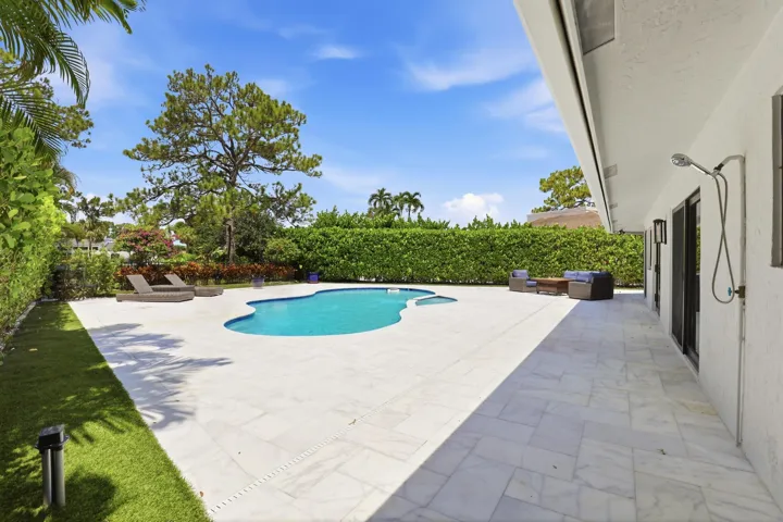 Discover your own private backyard sanctuary where modern luxury meets the natural beauty of Old Florida. Backing directly to a nature preserve, this extraordinary outdoor retreat offers a level of privacy rarely found in South Florida, creating a peaceful setting with no rear neighbors and lush tropical views in every direction. A newly renovated freeform pool and spa are surrounded by an expansive marble pool deck, offering the perfect backdrop for relaxing afternoons or effortless entertaining.Thoughtfully designed as an extension of the home, the backyard features multiple spaces to lounge, dine, and gather, all immersed in the serenity of the surrounding preserve. Whether enjoying your morning coffee, an evening swim, or hosting friends and family, every moment is enhanced by the tranquil landscape and exceptional sense of seclusion that defines this remarkable property.