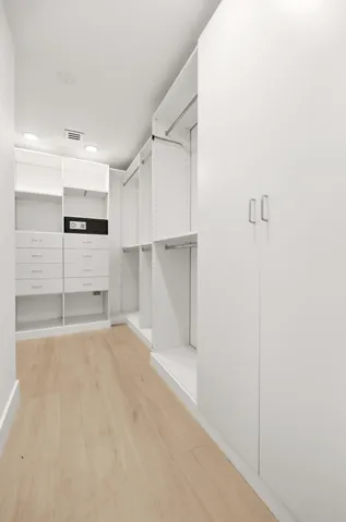 Designed for organization and convenience, this custom walk-in closet offers an impressive amount of storage with built-in shelving, abundant hanging space, multiple drawers, and dedicated accessory storage. Thoughtfully designed to maximize functionality, it provides a boutique-style dressing experience for all of your guests, while keeping everything neatly organized and easily accessible.