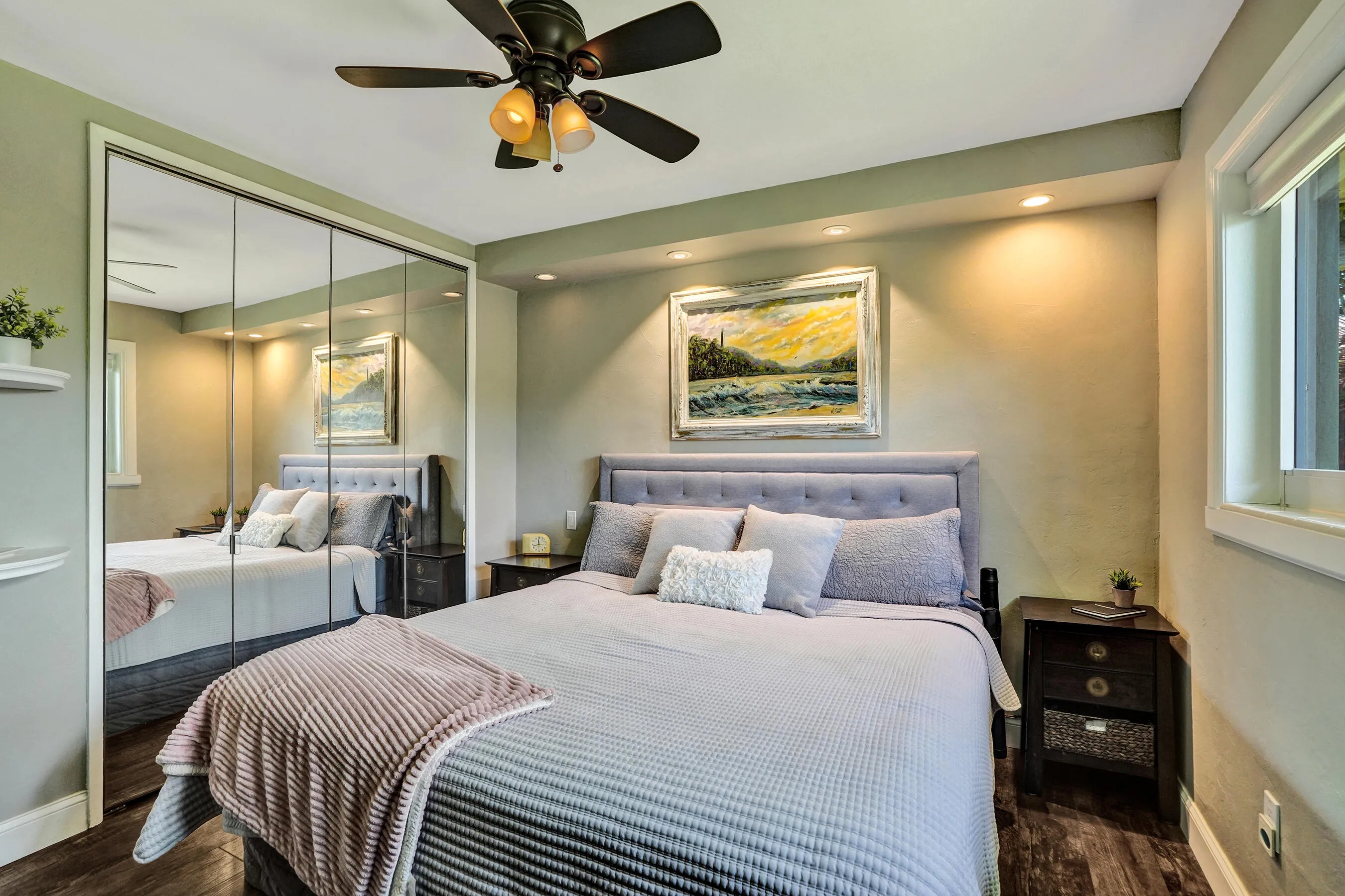 Private primary suite with custom built-in closet, luxury vinyl plank flooring, abundant natural light, and beautifully remodeled ensuite bath.