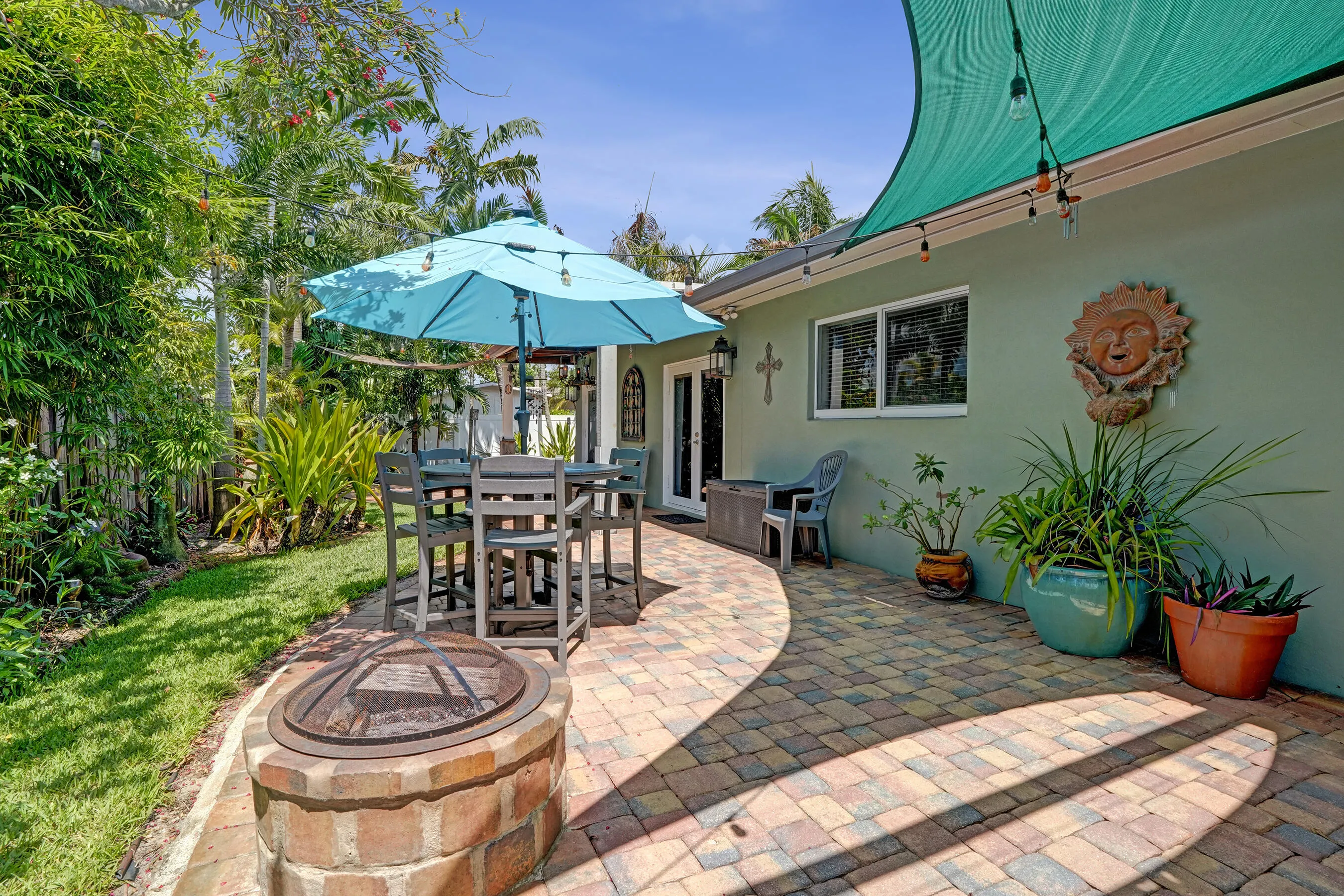 Resort-style outdoor entertaining area with built-in gas fire pit, multiple seating areas, and beautifully landscaped surroundings.