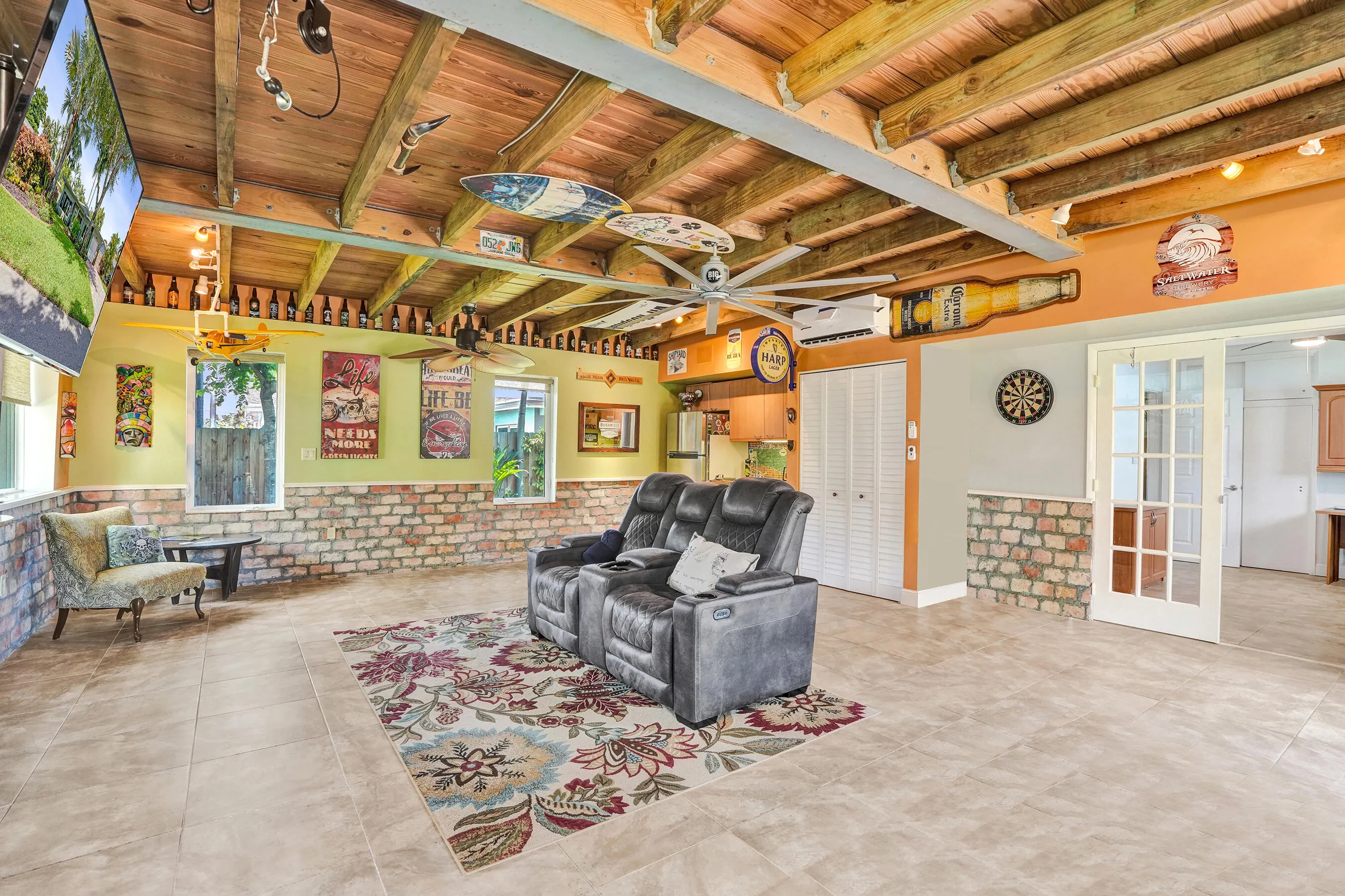 Extraordinary bonus room with tongue-and-groove stained wood ceiling, Chicago brick accents, wet kitchenette, ARAN Italian cabinetry, granite countertops, TV bar, dedicated mini-split A/C, and endless possibilities for media, fitness, or guest accommodations.