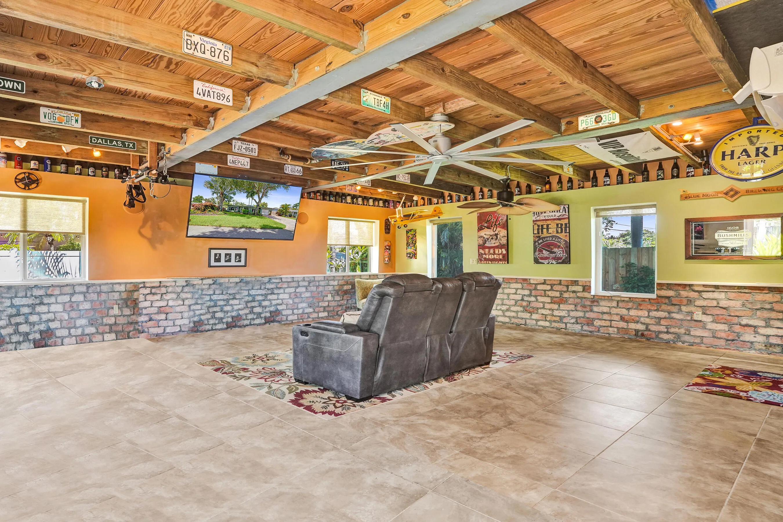 Extraordinary bonus room with tongue-and-groove stained wood ceiling, Chicago brick accents, wet kitchenette, ARAN Italian cabinetry, granite countertops, TV bar, dedicated mini-split A/C, and endless possibilities for media, fitness, or guest accommodations.