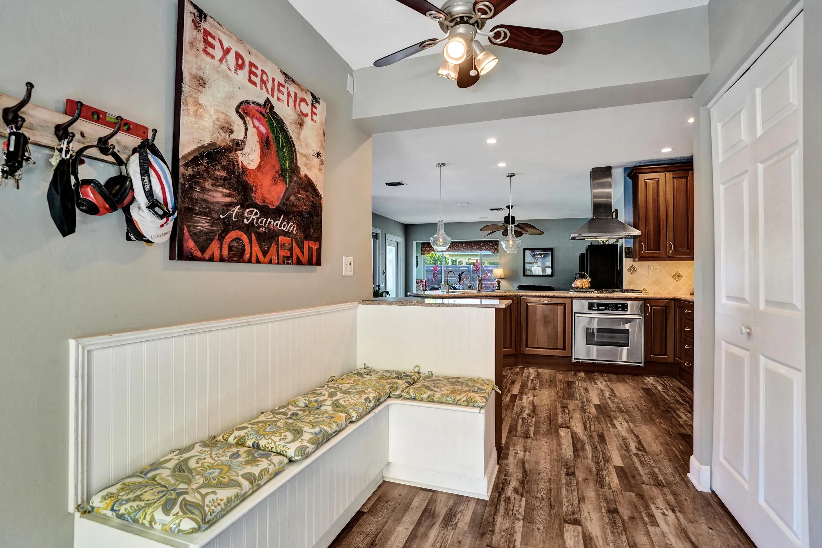 Charming breakfast nook with built-in banquet seating, additional hidden storage, and views of the tropical patio.
