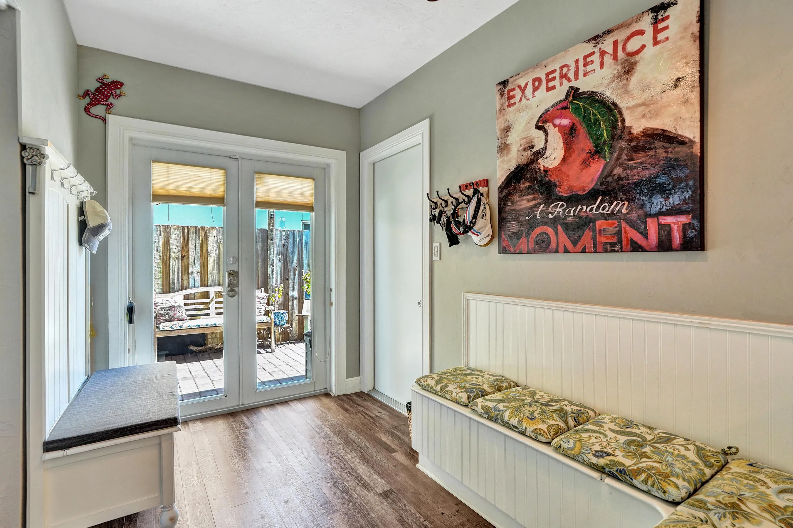 Charming breakfast nook with built-in banquet seating, additional hidden storage, and views of the tropical patio.