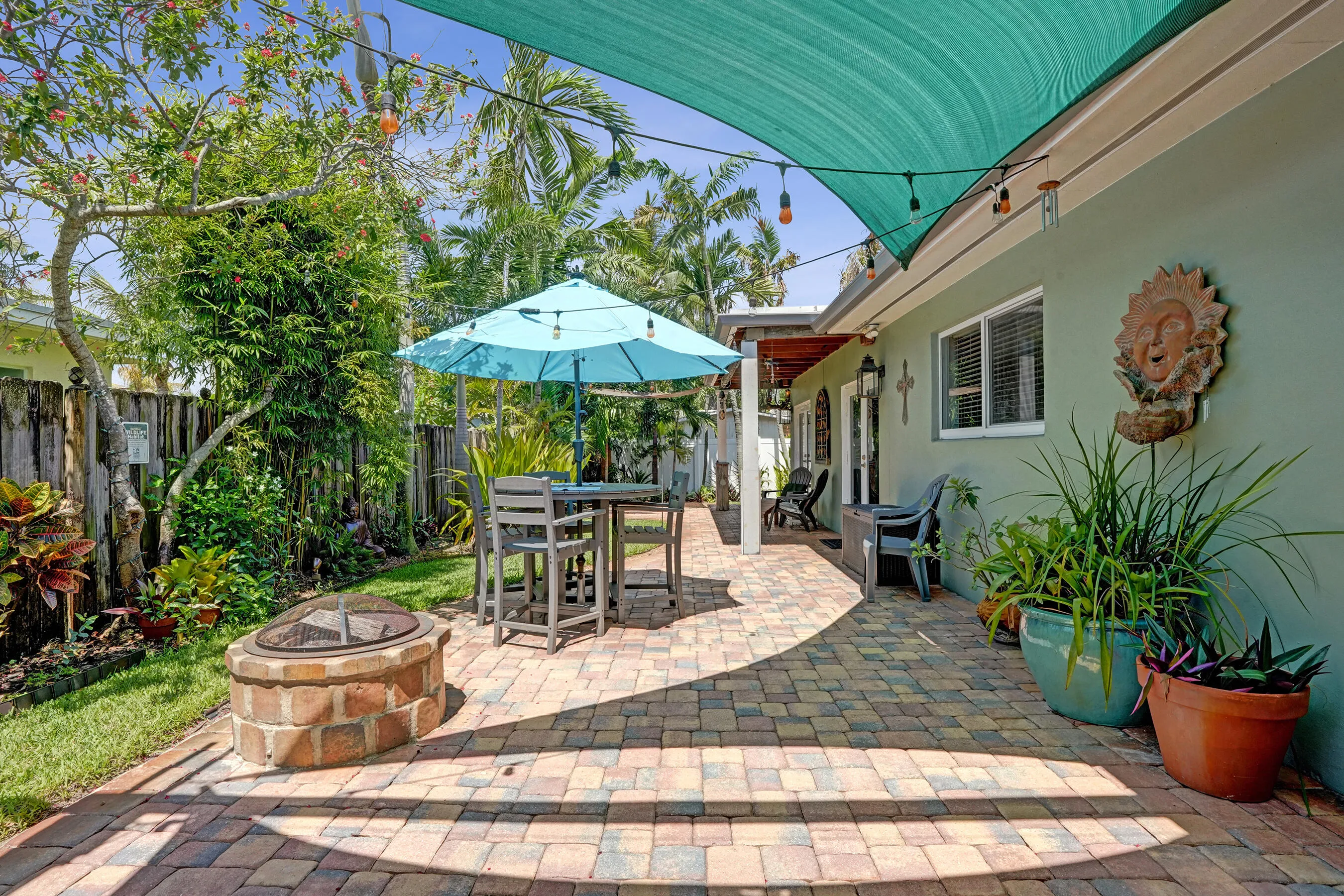 Resort-style outdoor entertaining area with built-in gas fire pit, multiple seating areas, and beautifully landscaped surroundings.