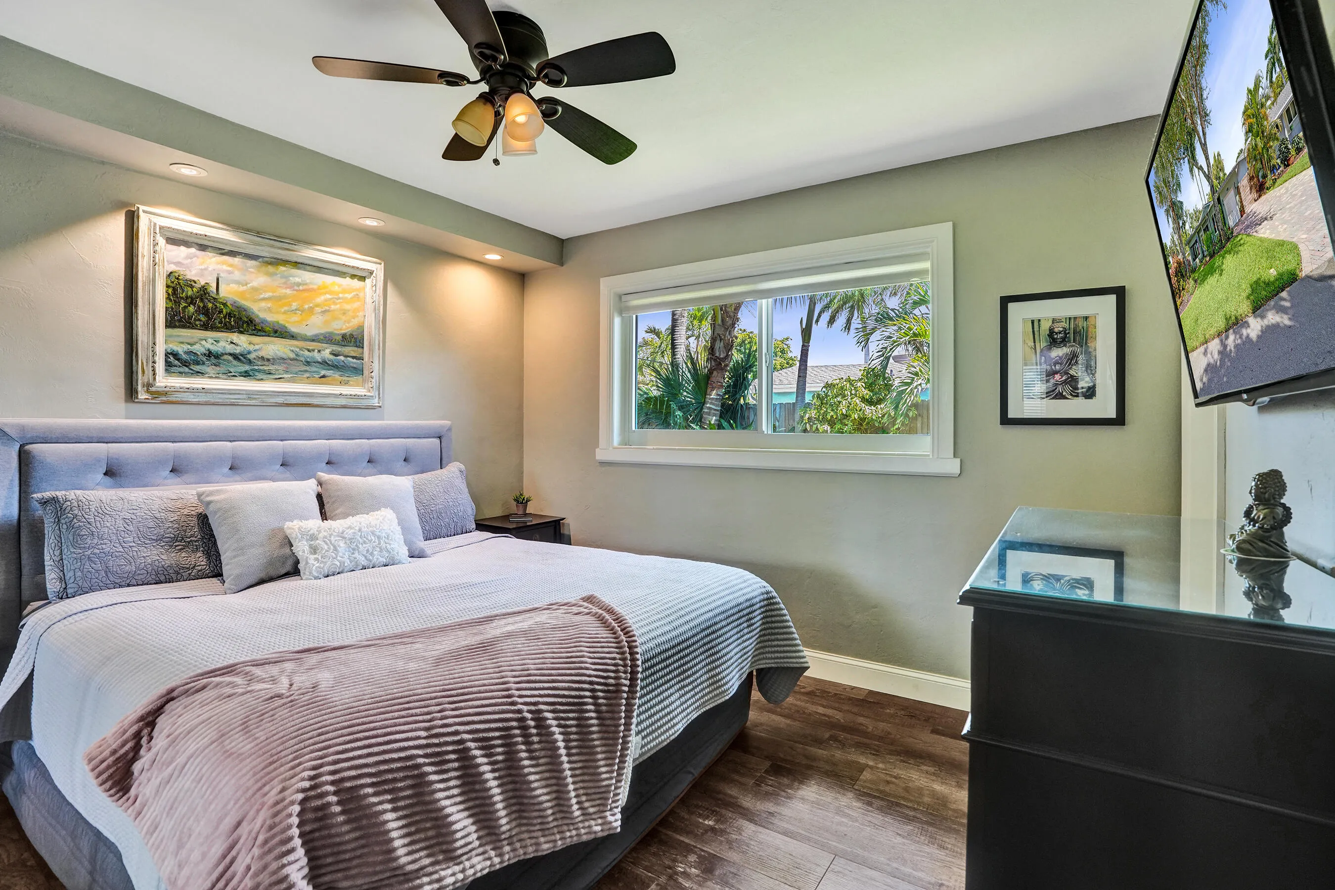 Private primary suite with custom built-in closet, luxury vinyl plank flooring, abundant natural light, and beautifully remodeled ensuite bath.