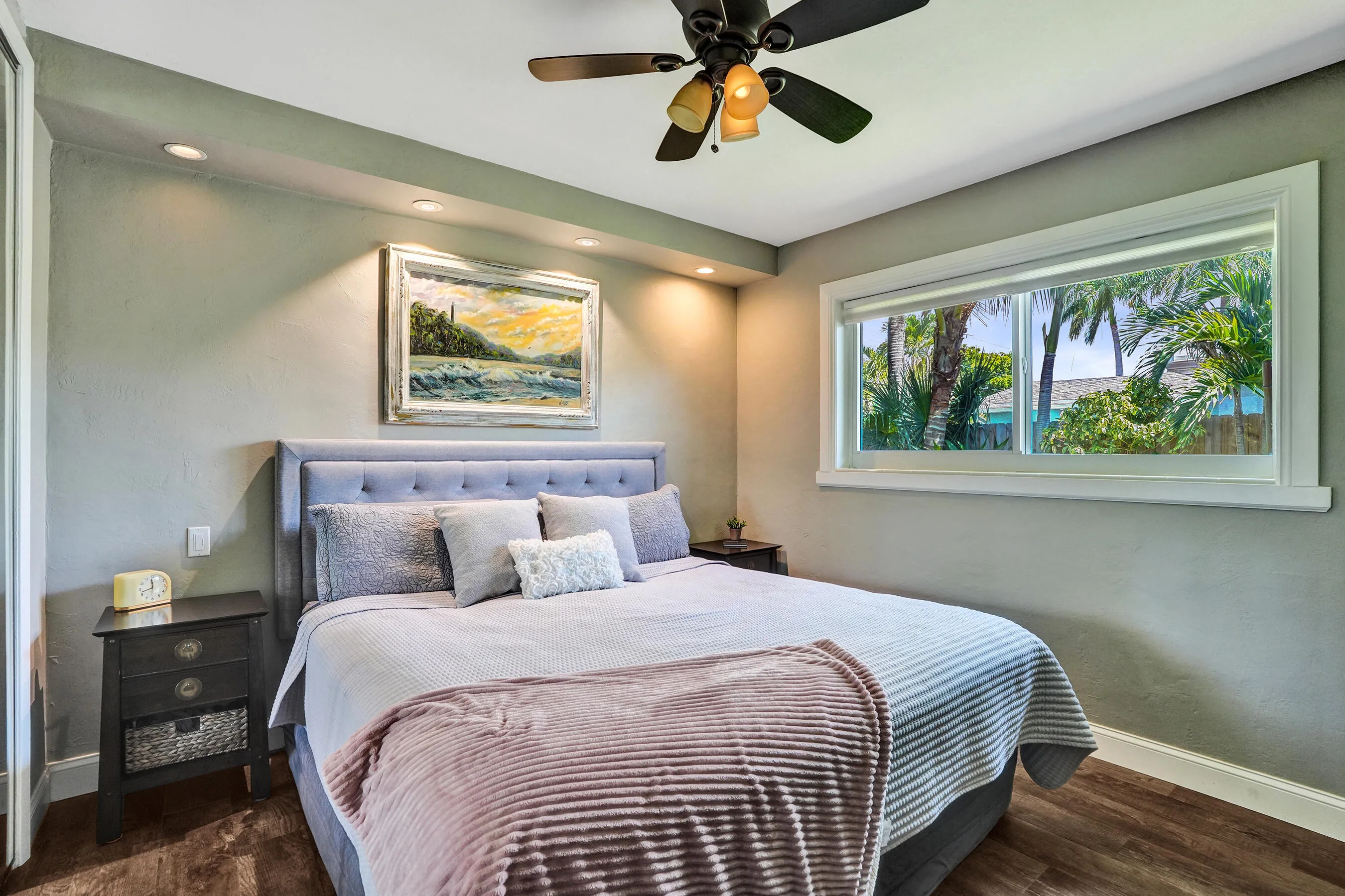 Private primary suite with custom built-in closet, luxury vinyl plank flooring, abundant natural light, and beautifully remodeled ensuite bath.